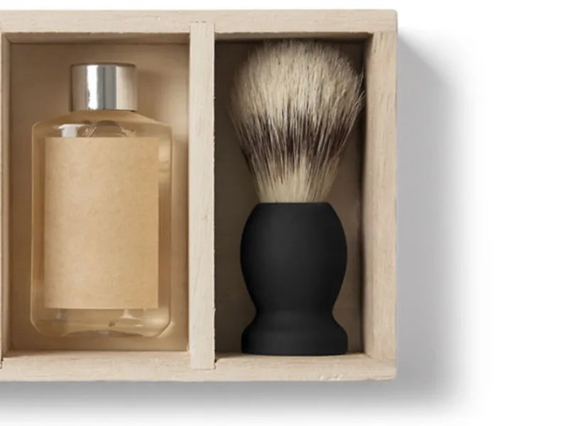 Elementos clásicos de barbería: navaja y brocha sobre madera